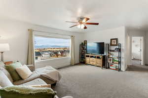 Living area featuring a ceiling fan and carpet