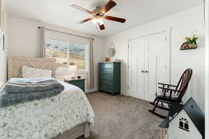Bedroom featuring carpet flooring, ceiling fan, and a closet