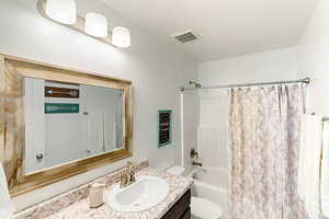 Full bath featuring vanity and shower / bathtub combination with curtain