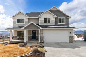 Craftsman-style home with a mountain view, stone siding, covered porch, a garage, and roof with shingles