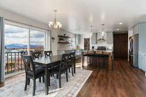Dining area with a mountain view, dark wood finished floors, and a chandelier