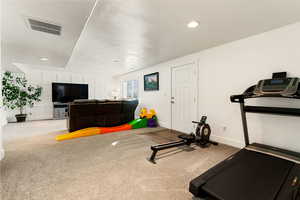 Exercise room featuring carpet, a textured ceiling, and recessed lighting