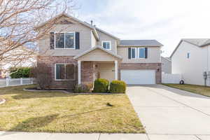 Traditional-style home with brick siding, concrete driveway, and a garage