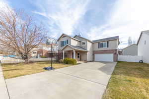 Traditional-style home featuring brick siding, an attached garage, and concrete driveway