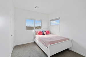 Bedroom featuring light carpet and baseboards