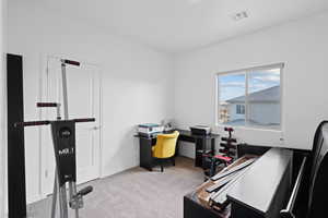 Home office with light carpet and baseboards