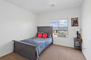 Bedroom featuring carpet and baseboards