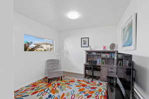 Sitting room with a desk and dark colored carpet