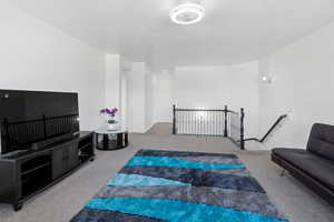 Living area featuring carpet flooring and baseboards