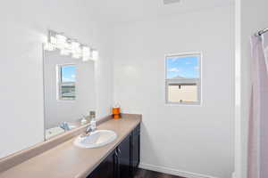 Bathroom with vanity, a shower with curtain, and dark wood-style floors