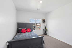 Bedroom with light colored carpet and baseboards