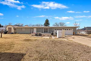 Single story home featuring a storage unit, concrete driveway, a garage, and board and batten siding