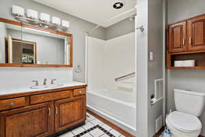 Bathroom with vanity, decorative backsplash, shower / tub combination, and light tile patterned floors