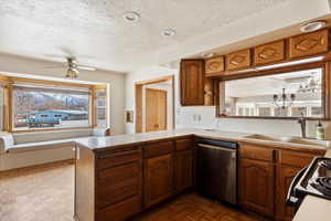 Kitchen featuring a peninsula, dishwasher, wood finish cabinetry, black range with electric stovetop, and a textured ceiling