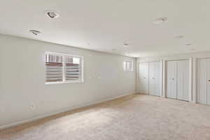 Unfurnished bedroom featuring multiple closets, carpet flooring, and multiple windows