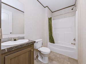 Full bathroom featuring vanity, shower / tub combo with curtain, crown molding, and wallpapered walls