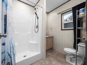 Bathroom with a stall shower, vanity, and ornamental molding