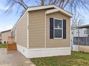 View of property exterior featuring a lawn