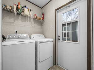 Laundry room featuring washer and dryer and crown molding