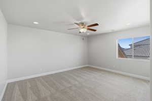 Spare room featuring recessed lighting, light colored carpet, and a ceiling fan