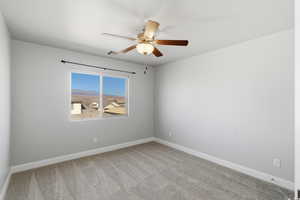 Spare room featuring light carpet and a ceiling fan