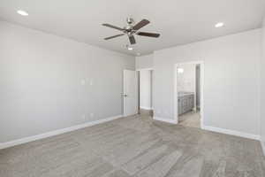 Unfurnished bedroom featuring light carpet, ceiling fan, recessed lighting, and ensuite bath