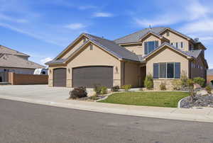 Traditional home with stone siding, stucco siding, an attached garage, and concrete driveway