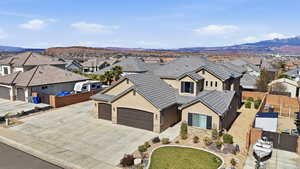 View of front facade featuring stucco siding, a residential view, a mountain view, driveway, and stone siding