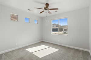 Spare room featuring a ceiling fan and light carpet