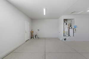 Garage with water heater and baseboards