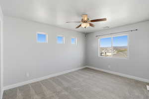 Unfurnished room featuring light colored carpet and ceiling fan