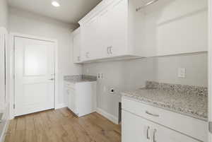 Laundry room featuring light wood finished floors, cabinet space, electric dryer hookup, hookup for a washing machine, and recessed lighting