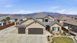 View of front of home with stucco siding, stone siding, a garage, and a residential view