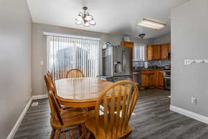 Dining room featuring dark wood finished floors and suspended lighting