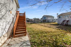 Fenced backyard featuring a trampoline, a residential view, and a wooden deck