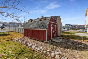 View of shed with a fenced backyard, a residential view, and a trampoline