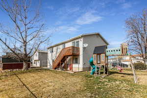 Rear view of property featuring stairs and a playground