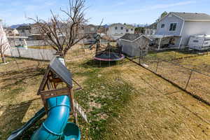 Fenced backyard with a trampoline and a residential view