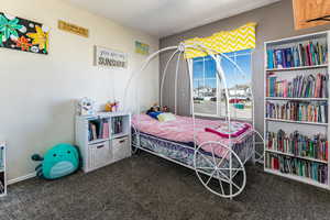 Bedroom featuring dark carpet