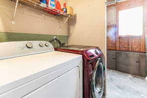 Laundry room featuring unfinished concrete flooring and washing machine and dryer