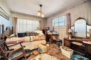Bedroom featuring wallpapered walls and suspended lighting