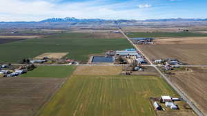 Aerial overview of property's location with rural landscape, extensive farmland, and a mountainous background