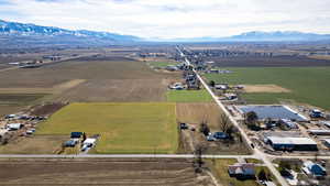 Aerial overview of property's location with a mountainous background, rural landscape, and extensive farmland