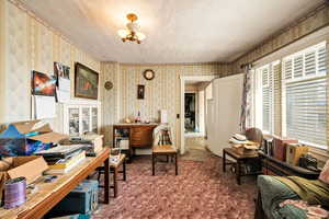 Office space featuring wallpapered walls and dark colored carpet
