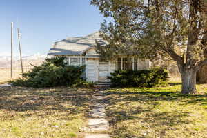 View of front of home with roof with shingles and a front lawn