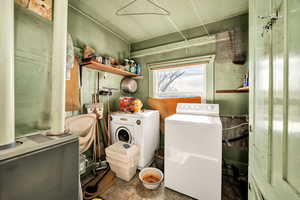 Laundry area featuring heating unit, washing machine and dryer, and concrete floors