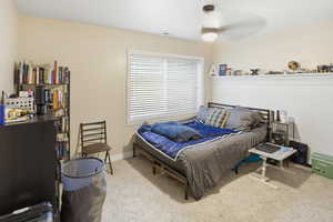 Bedroom with light carpet and a ceiling fan
