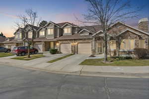 Traditional-style house featuring concrete driveway and stone siding