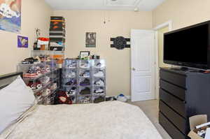 Bedroom with attic access and light carpet