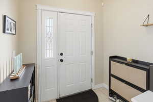 Entrance foyer with light tile patterned floors and plenty of natural light